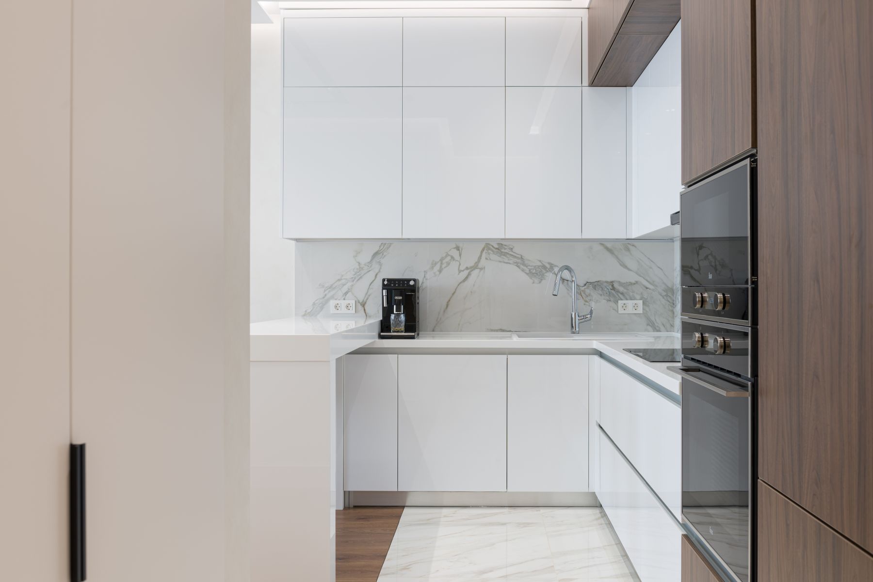 Cocina blanca en U con columna de hornos