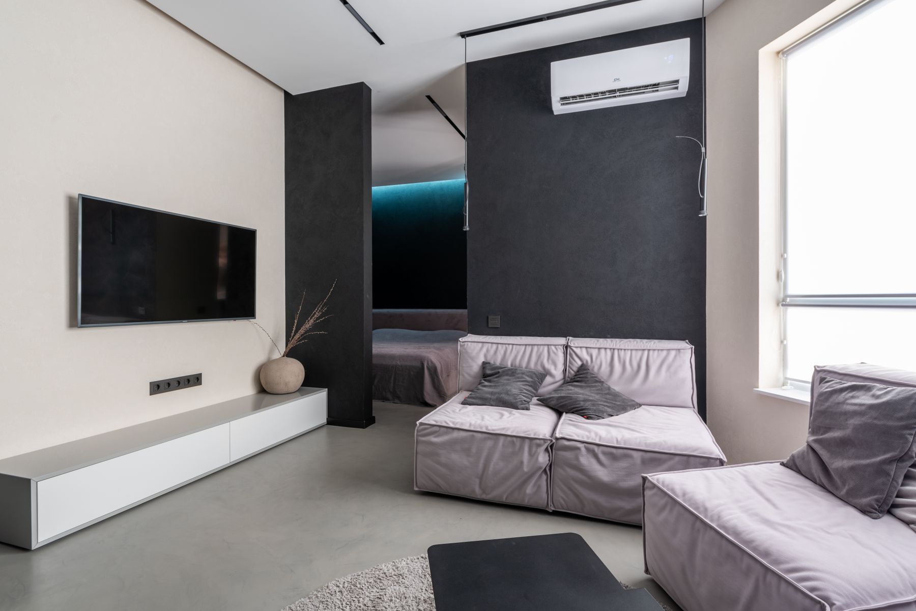 Salón con sofás claros y aire acondicionado en la pared