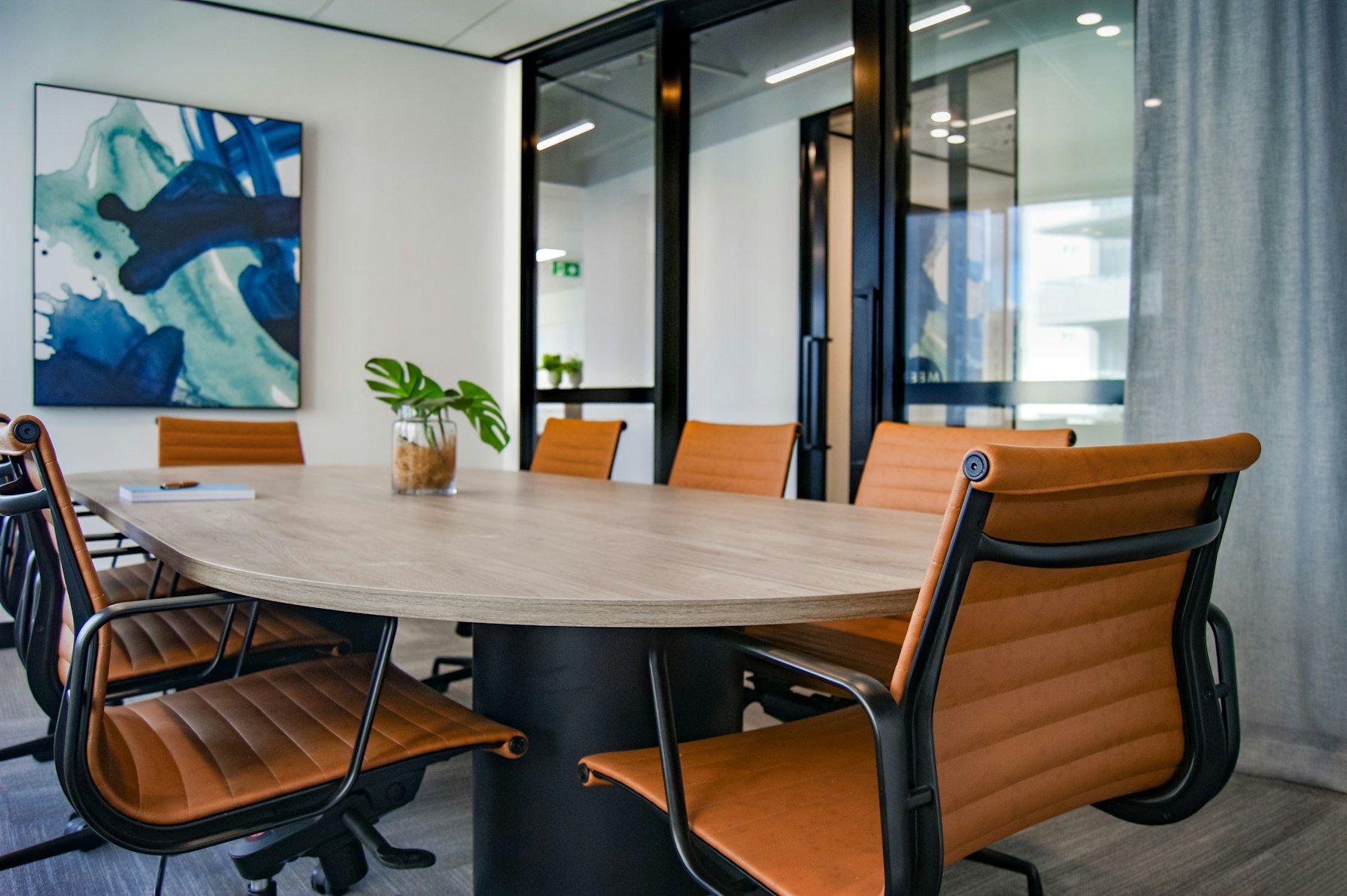Sala de reuniones con mesa de madera y sillas de cuero