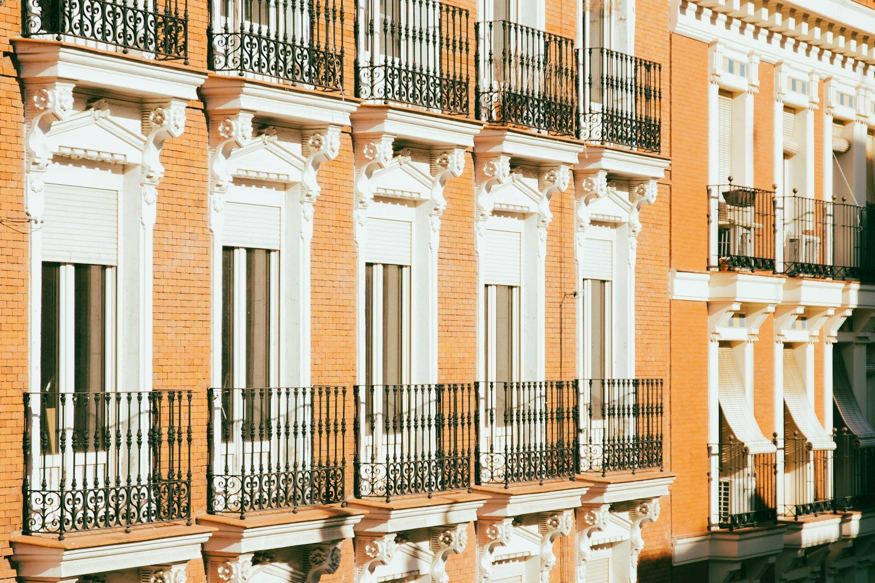 Fachada de ladrillo con balcones de forja en Madrid