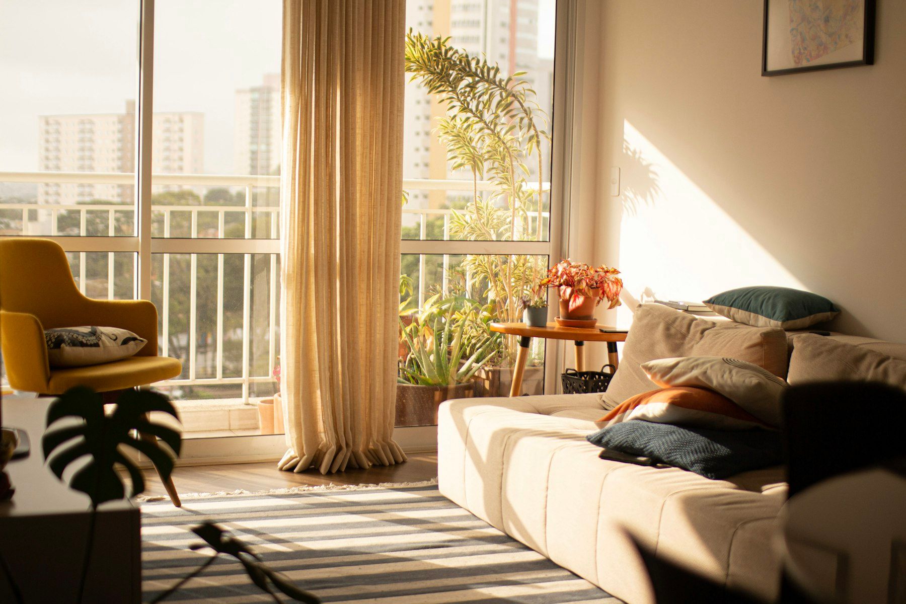 Salón soleado con sofá y ventanal a la terraza