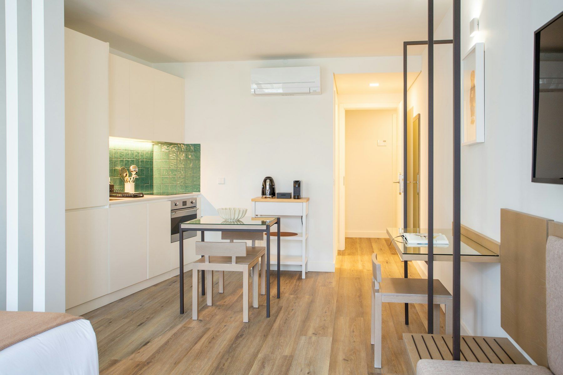 Estudio con cocina abierta, mesa para dos y armarios integrados