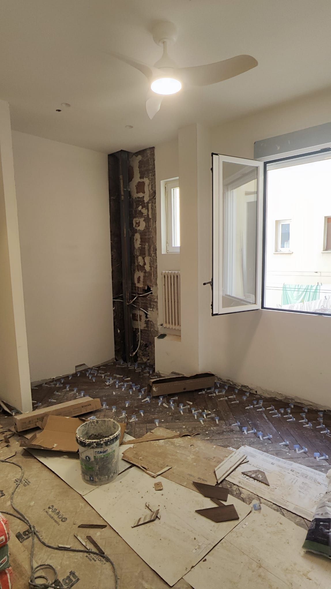 Estancia en obra con las rozas de las instalaciones abiertas junto a la ventana