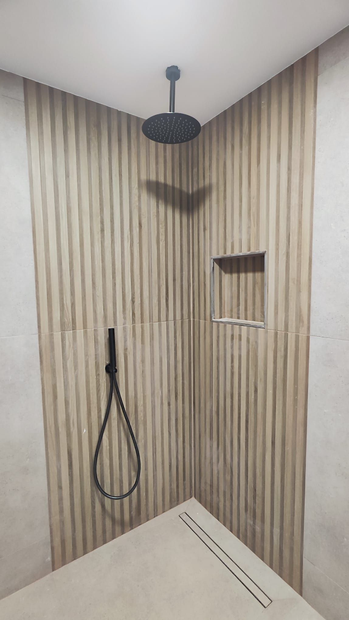 Ducha con rociador de techo, grifería negra empotrada y sumidero lineal