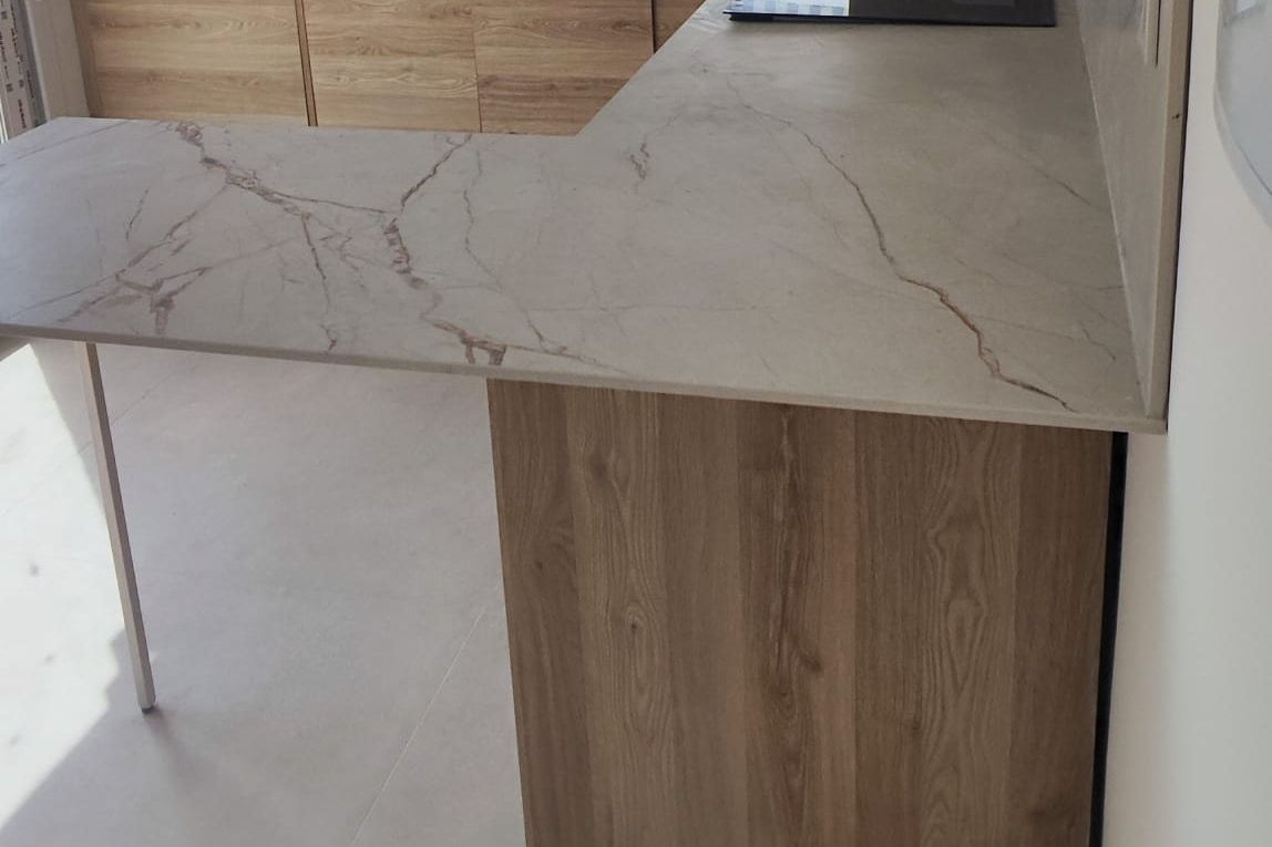 Península de la cocina con encimera de efecto mármol y frente de madera