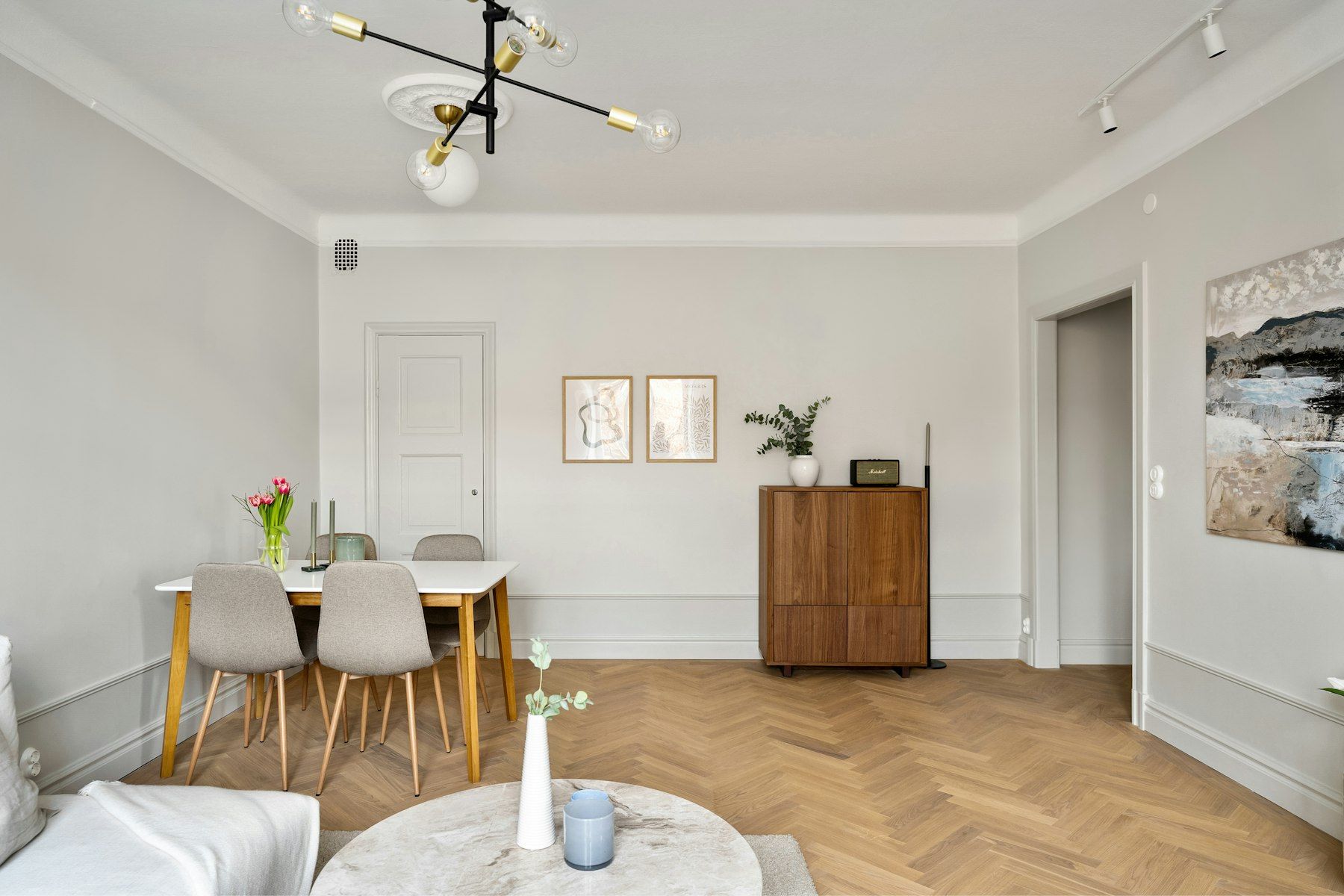 Comedor en un piso clásico con molduras y suelo de madera