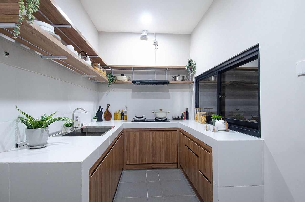Cocina en U con muebles de madera y encimera blanca