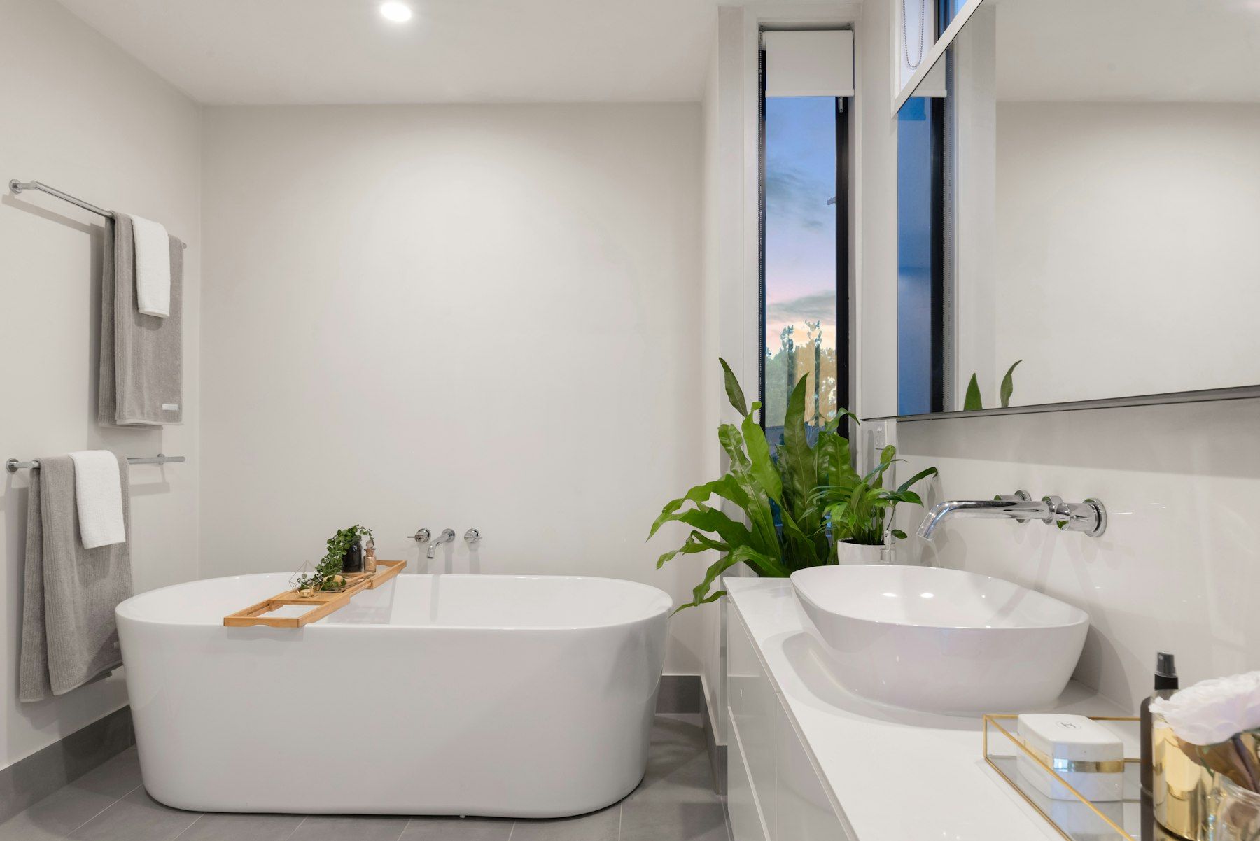 Baño blanco con bañera exenta y plantas