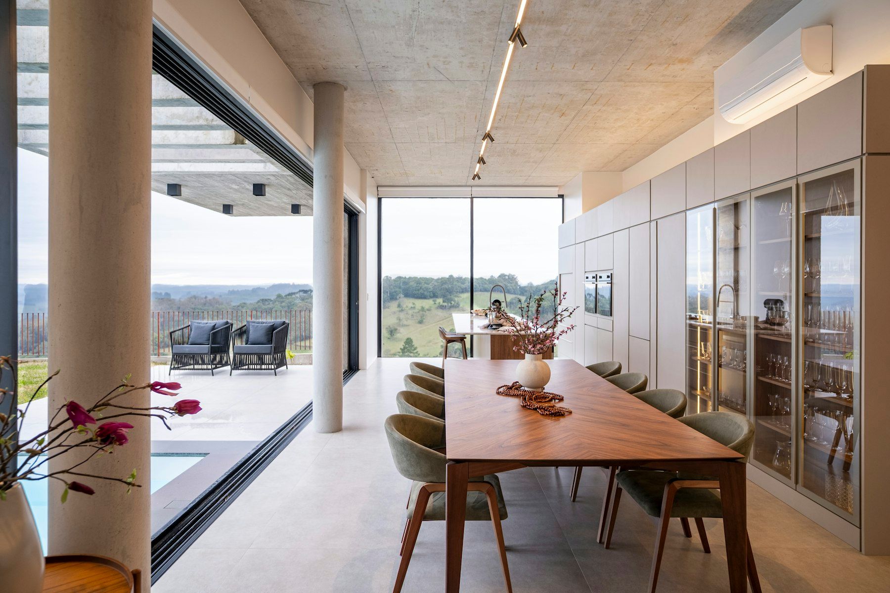 Comedor con mesa larga de madera y un split sobre los armarios