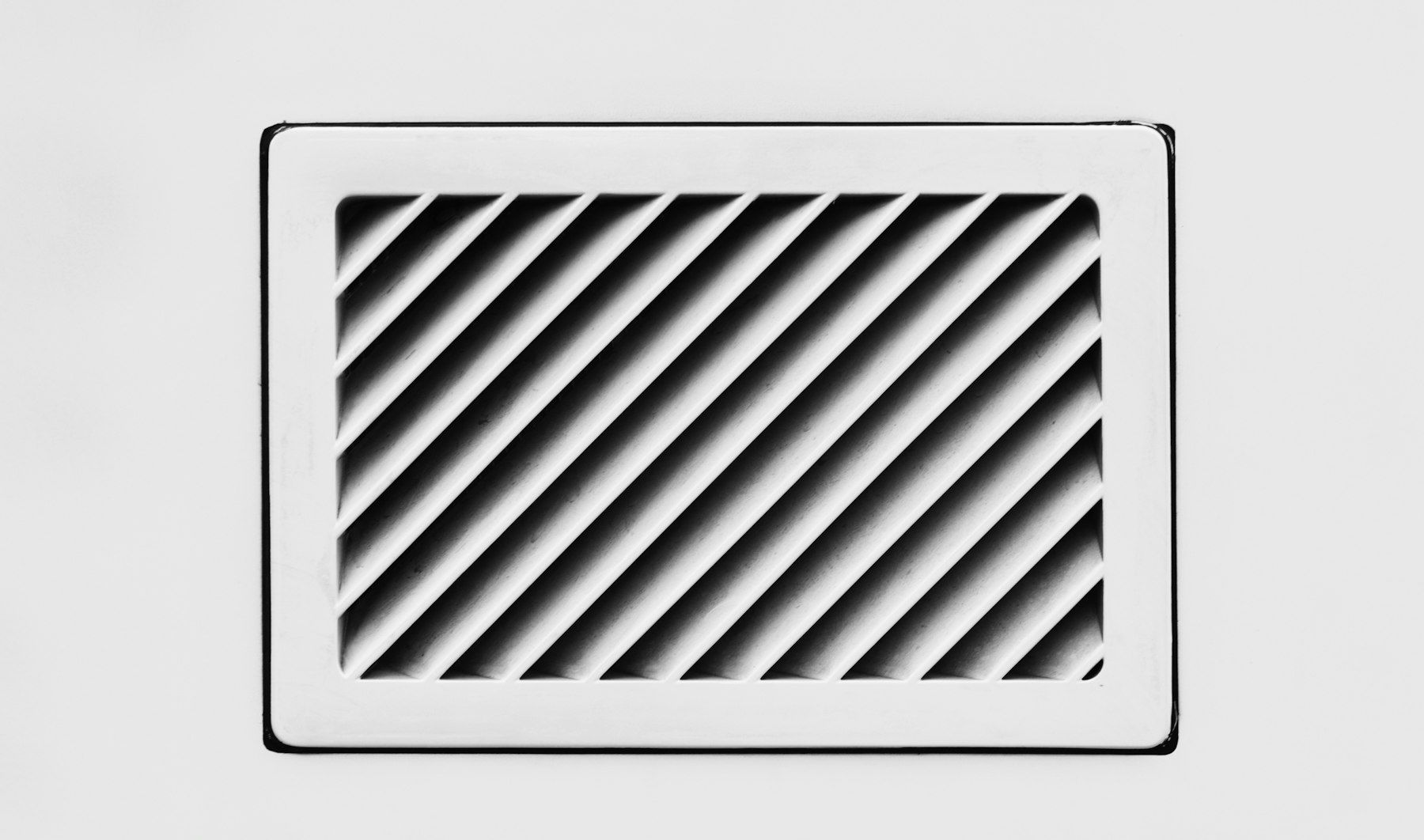 Rejilla de ventilación blanca con lamas en diagonal