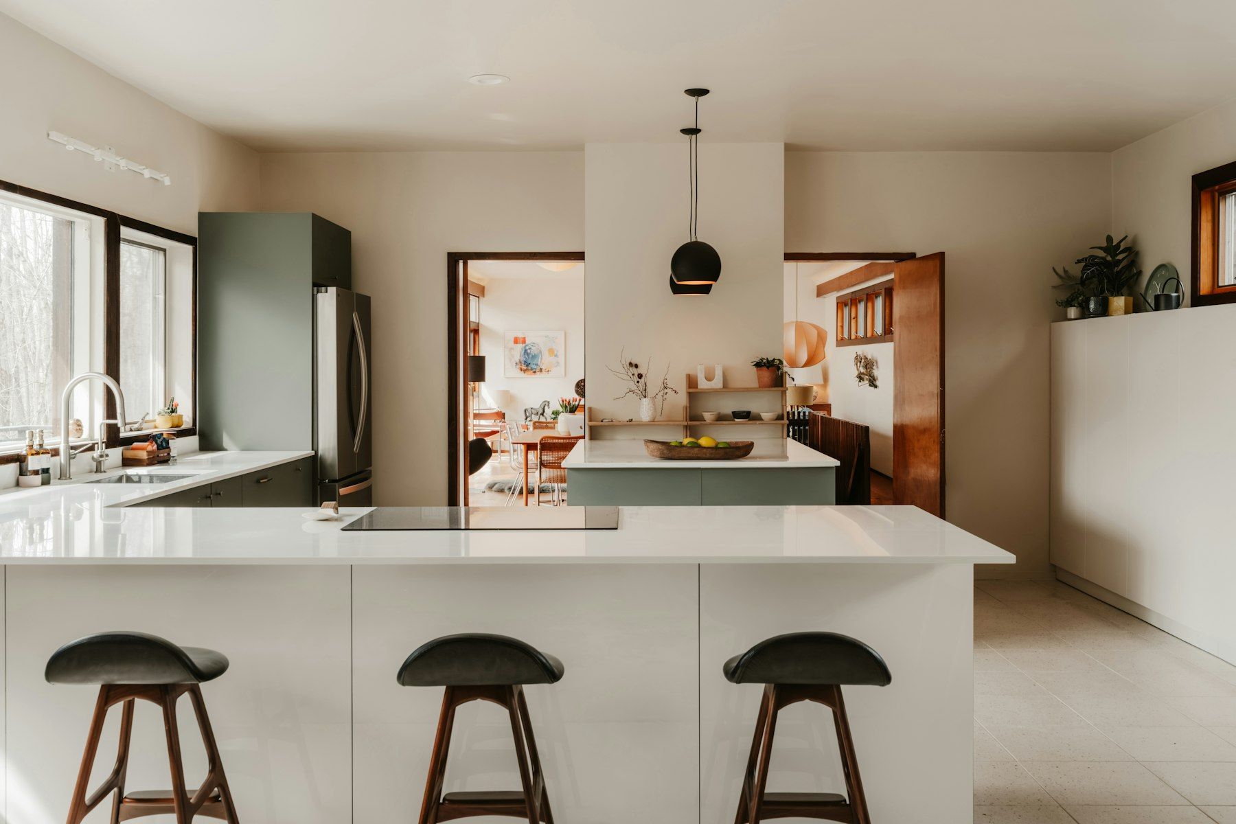Cocina abierta y luminosa con barra y taburetes de madera
