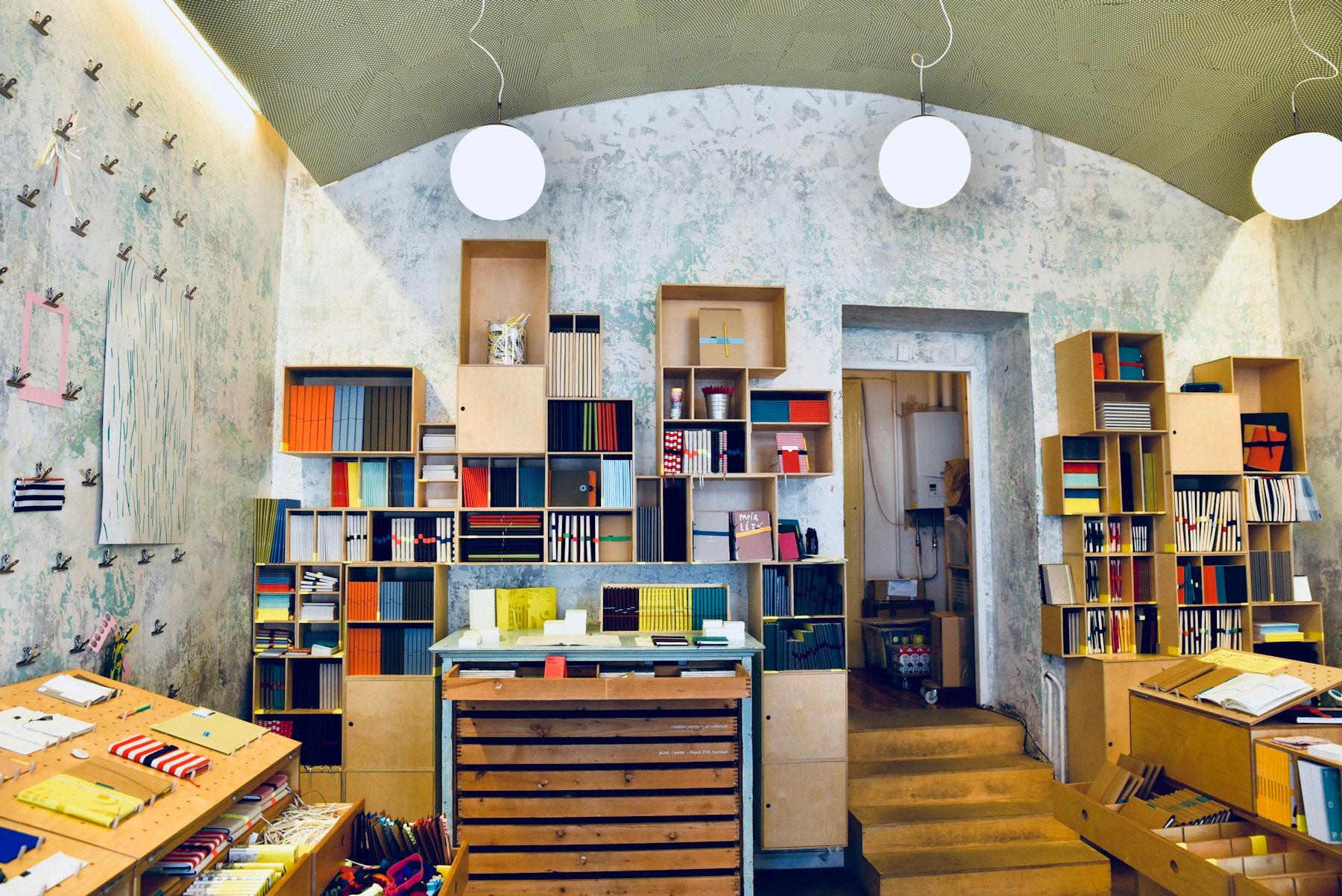 Papelería con estanterías de madera y techo abovedado