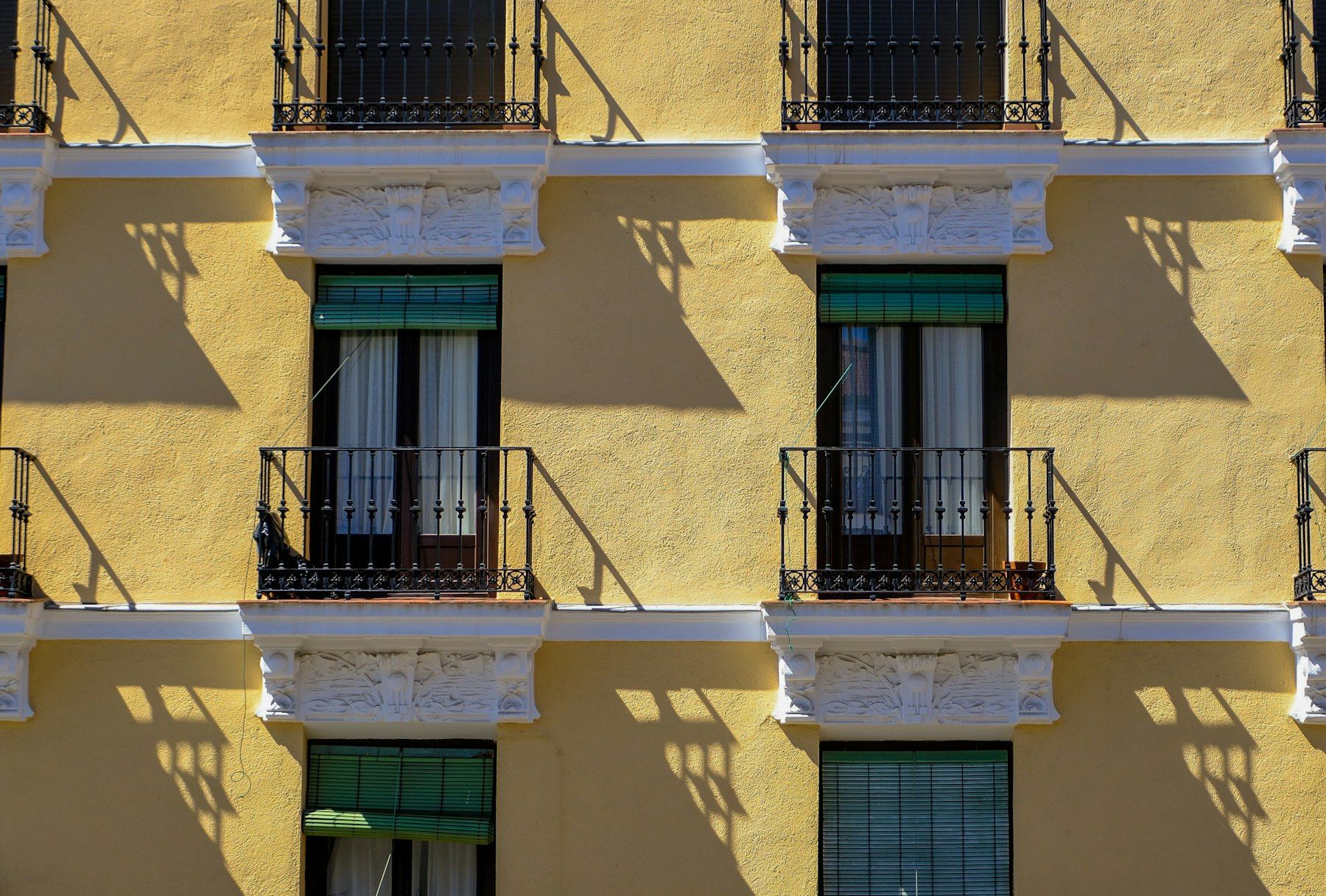 Fachada con balcones de forja y contraventanas