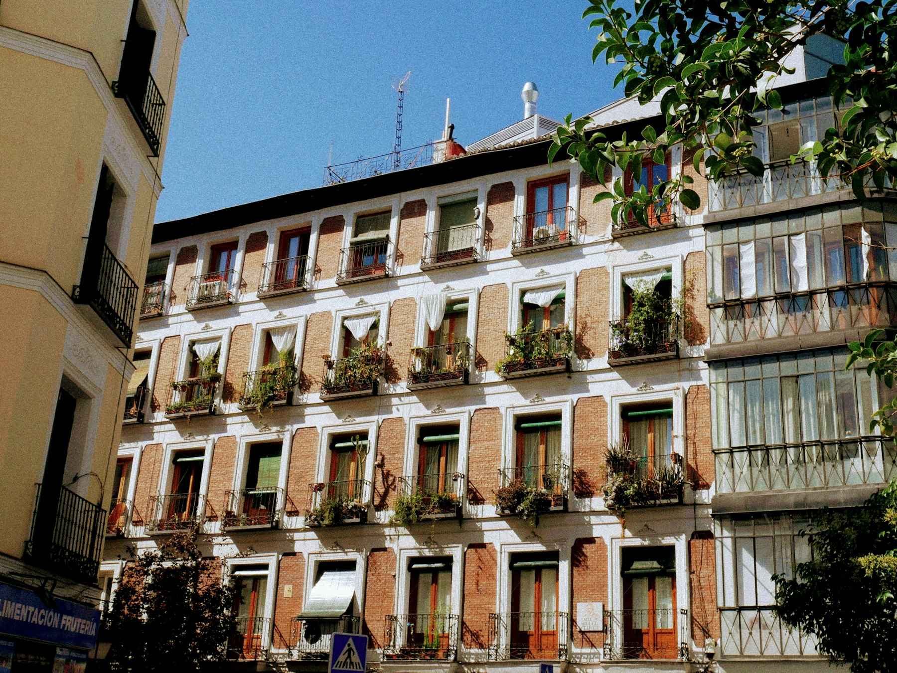 Edificio de ladrillo con balcones y plantas