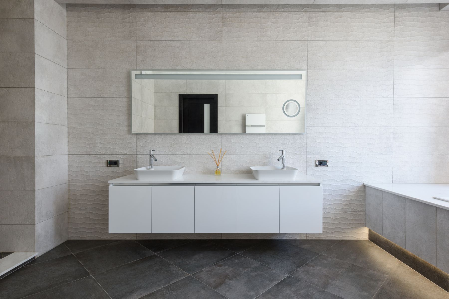 Baño con mueble blanco suspendido y doble lavabo
